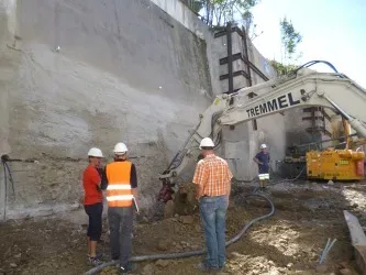 Bauarbeiter mit Warnwesten an der Baugrube